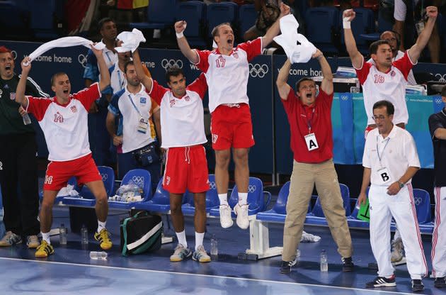 The Croatian bench celebrate after scoring a goal in the men's handball gold medal match between Gemany and Croatia on August 29, 2004 during the Athens 2004 Summer Olympic Games at the Faliro Coastal Zone Olympic Complex Sports Pavilion in Athens, Greece. (Photo by Doug Pensinger/Getty Images)