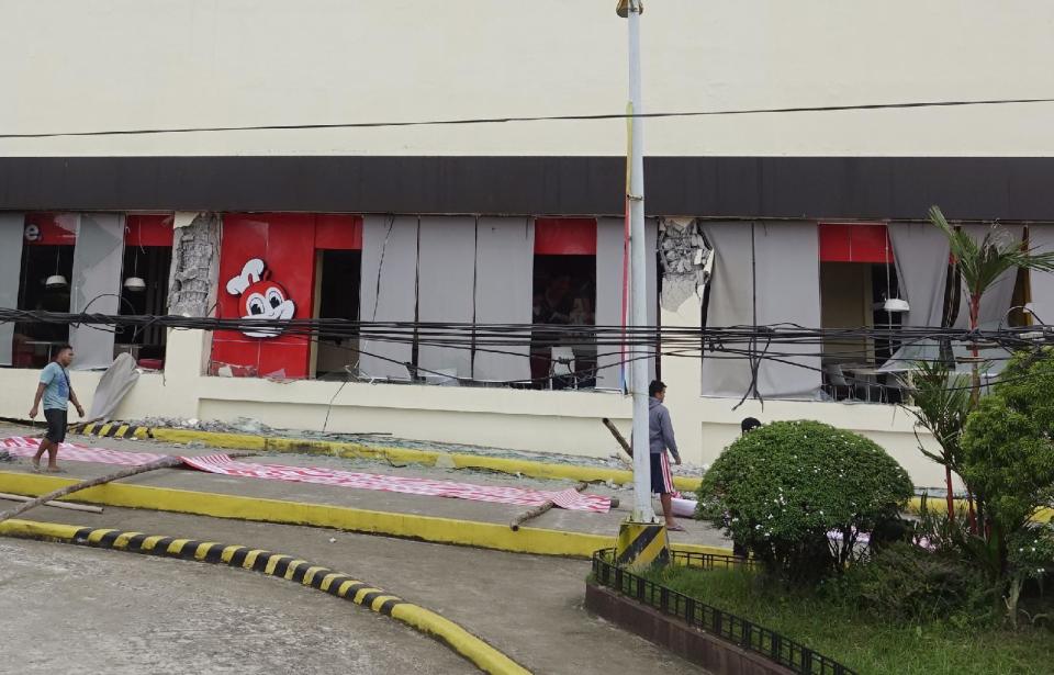 Workers prepare to cover a damaged fast food chain in Surigao hours after a powerful earthquake rocked Surigao del Norte province Saturday, Feb. 11, 2017 in southern Philippines. The late Friday quake with a magnitude of 6.5 roused residents from sleep in the province, sending hundreds to flee their homes. (AP Photo)