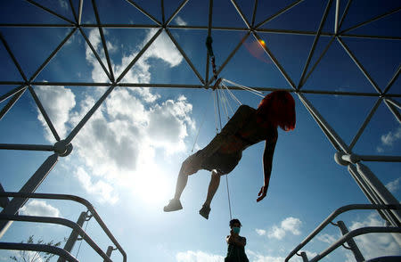 Kaitlin, 28, from the United States is suspended from hooks pierced through her skin by the professional body artist Dino Helvida in Zagreb, Croatia June 7, 2016. REUTERS/Antonio Bronic