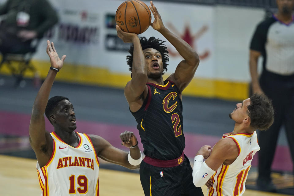 Cleveland Cavaliers' Collin Sexton (2) shoots against Atlanta Hawks' Tony Snell (19) and Trae Young (11) in the first half of an NBA basketball game, Tuesday, Feb. 23, 2021, in Cleveland. (AP Photo/Tony Dejak)