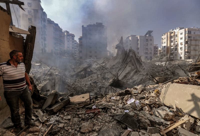 A man inspects the damage after Israeli airstrikes on a street in Beirut's southern suburbs. Stringer/dpa