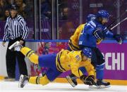 Sweden's Erik Karlsson (65) is tripped up by Finland's Tuomo Ruutu (15) during the third period of the men's ice hockey semi-final game at the Sochi 2014 Winter Olympic Games, February 21, 2014. REUTERS/Mark Blinch