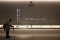 A woman looks at displays at the newly opened Tokyo Olympic Museum located near the New National Stadium, Sunday, Feb. 23, 2020, in Tokyo. (AP Photo/Jae C. Hong)