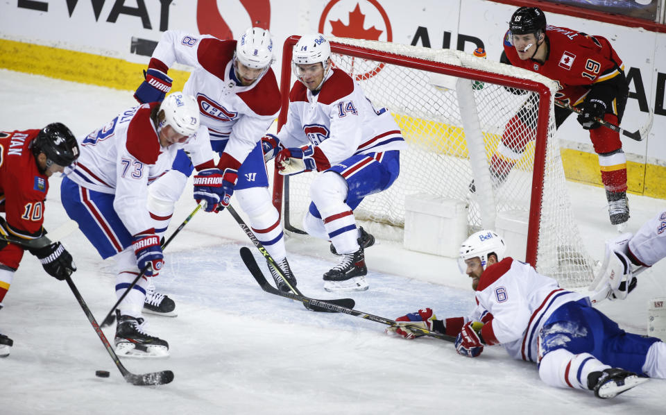 Montreal Canadiens', second from left to right, Tyler Toffoli, Ben Chiarot, Nicholas Suzuki and Shea Weber block the net against Calgary Flames' Derek Ryan, left, as Flames' Matthew Tkachuk, top right, watches during second-period NHL hockey game action in Calgary, Alberta, Friday, April 23, 2021. (Jeff McIntosh/The Canadian Press via AP)