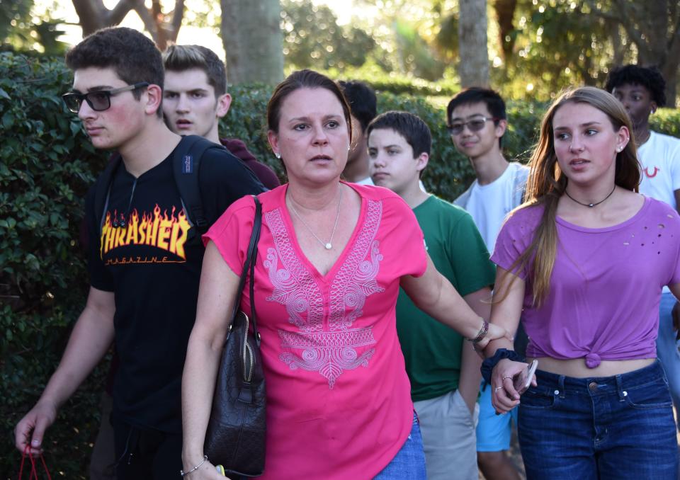 Students and adults leave following a shooting at Marjory Stoneman Douglas High School in Parkland, Florida.