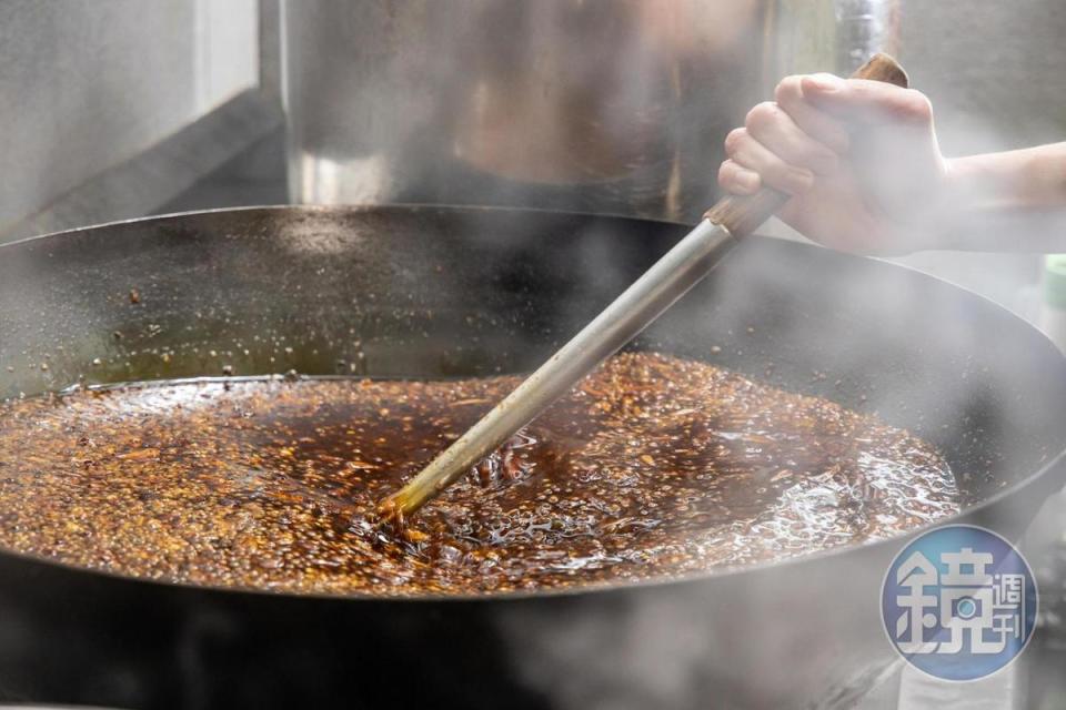 這鍋麻辣底料得用人力不斷攪拌好幾個小時，是真真正正的苦力活。