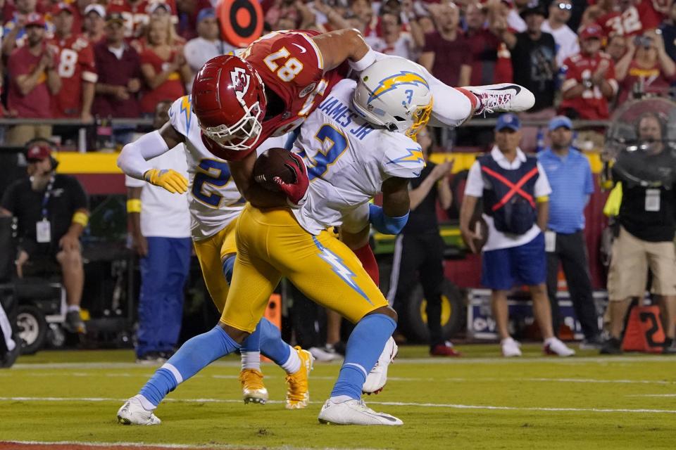 Kansas City Chiefs tight end Travis Kelce (87) is stopped short of the goal line by Los Angeles Chargers safety Derwin James Jr. (3) during the second half of an NFL football game Thursday, Sept. 15, 2022, in Kansas City, Mo. (AP Photo/Ed Zurga)