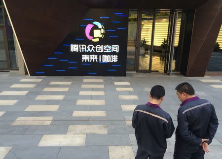 Men stand in front of the gate of Tencent Space, a flagship technology incubator in Tianjin, China, May 17, 2016. REUTERS/Sue-Lin Wong