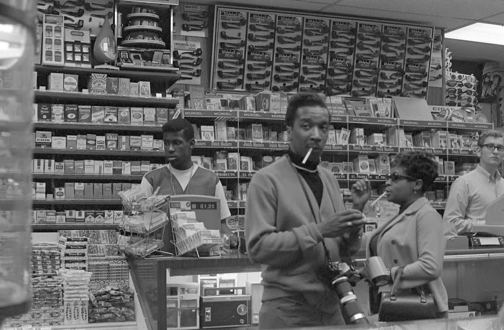 View of clerks and customers in an unidentified store that offers a wide range of cigarettes, as well as other tobacco-related products, candy, and portable radios at Coney Island, Brooklyn, New York, New York, July 4, 1968