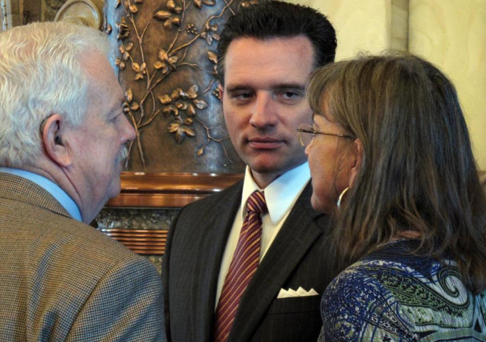 Kansas state Sens. Ray Merrick, left, of Stilwell; Ty Masterson, center, of Andover, and Susan Wagle, right, of Wichita, all Republicans, confer during a debate, Wednesday, March 21, 2012, at the Statehouse in Topeka, Kan. All three support GOP Gov. Sam Brownback's push to lower income taxes to stimulate the economy. (AP Photo/John Hanna)