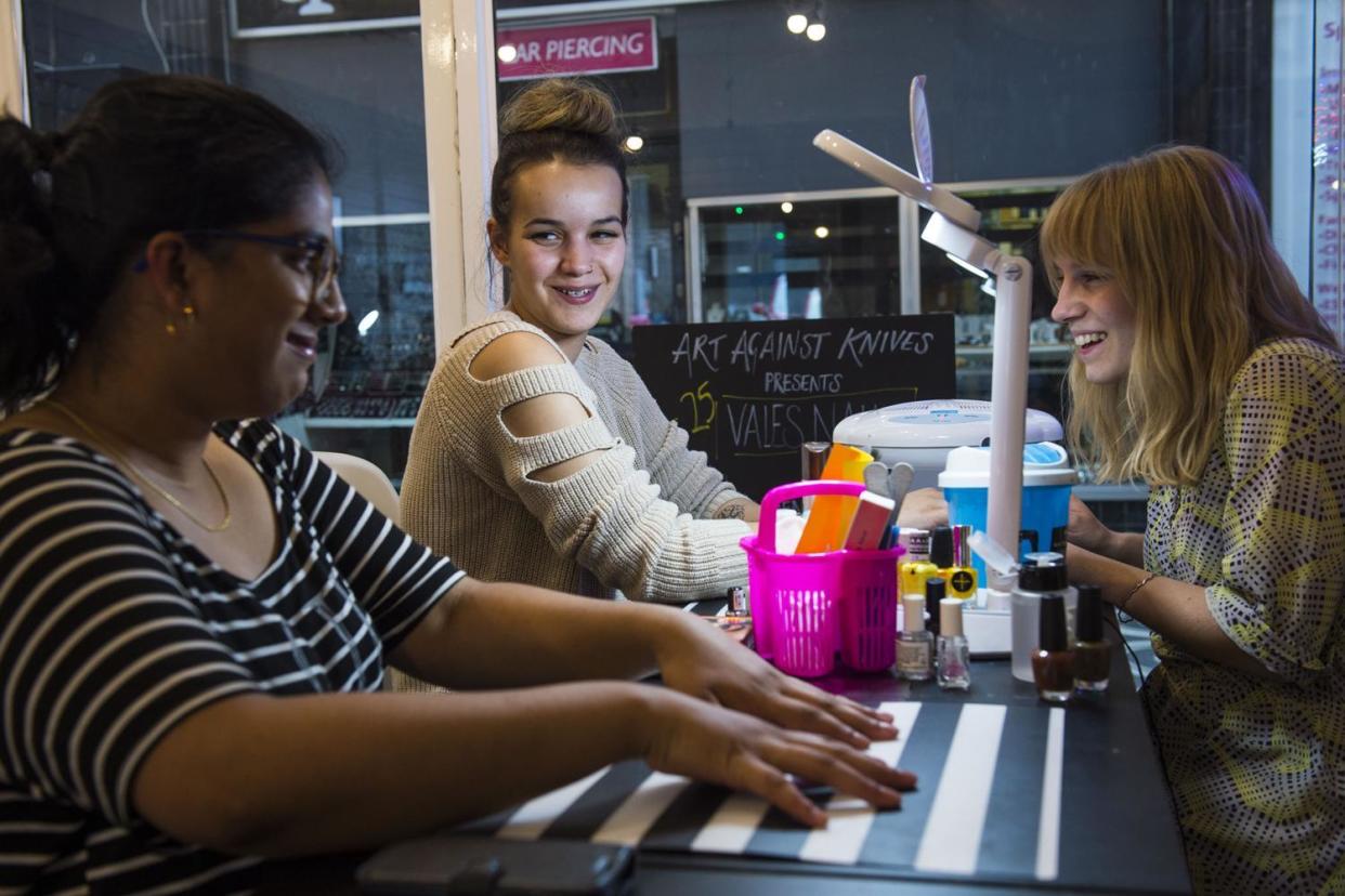 Support: Alisha Shepherd, far right, paints nails at Vales Nails in North Finchley. The technicians are mentors and can help young women who may be vulnerable to involvement in knife crime: Lucy Young