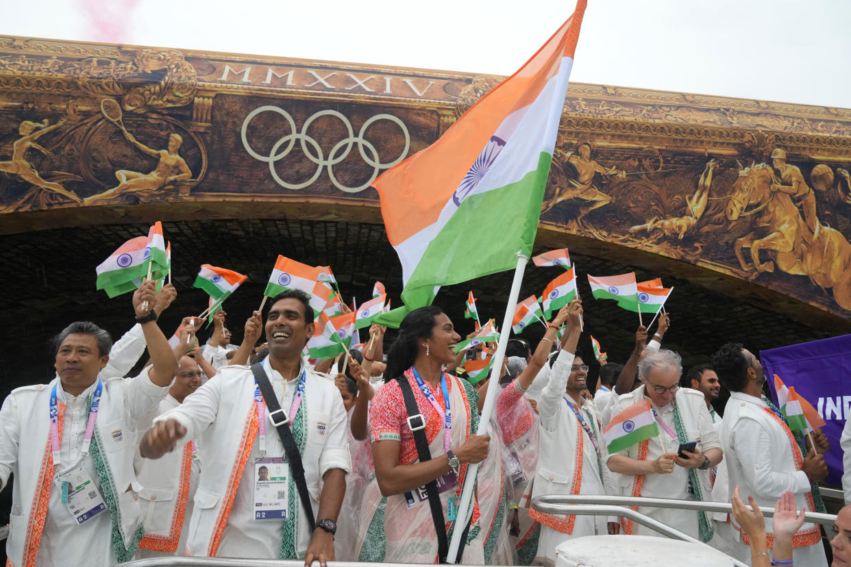 Indian athletes wave their national flags from their delegation's boat. / Credit: Aijaz Rahi / AP