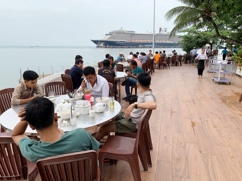 People eat breakfast at a restaurant near the MS Westerdam cruise ship in Sihanoukville