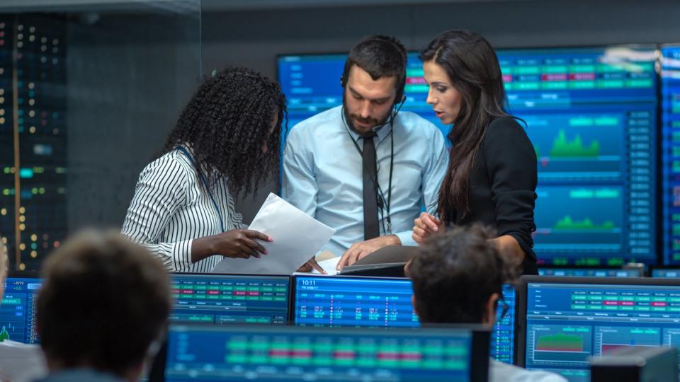 Three analysts debating stock trades.