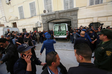 Media and police surround a convoy of police vehicles as businessmen suspected of corruption are driven to court in Algiers, Algeria April 23, 2019. REUTERS/Ramzi Boudina