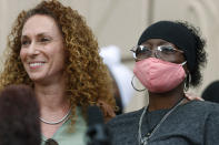 Sheneen McClain, right, is hugged by family attorney Mari Newman at the memorial site across the street from where McClain's 23-year-old son, Elijah, was stopped by Aurora, Colo., Police Department officers while walking home as family members hold a news conference Friday, July 3, 2020, in Aurora, Colo. Three Aurora Police Department officers have left the force after photographs surfaced of them reenacting the chokehold used on McClain across the road from the memorial. (AP Photo/David Zalubowski)