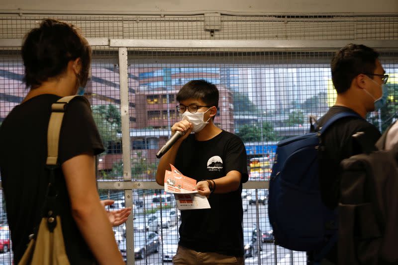 Pro-democracy activist Joshua Wong distributes leaflets encouraging people to send postcards to twelve Hong Kong residents being held in the Chinese mainland after attempting to flee to Taiwan, in Hong Kong