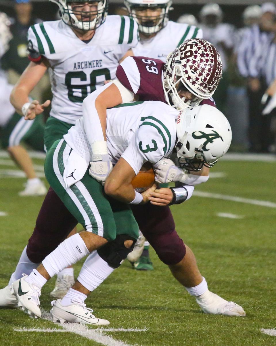 Caravel's Ian Smith sacks Archmere's Miles Kempski late in the fourth quarter of Caravel's 35-13 win in the DIAA Class 2A championship at Delaware Stadium, Saturday, Dec. 2, 2023.