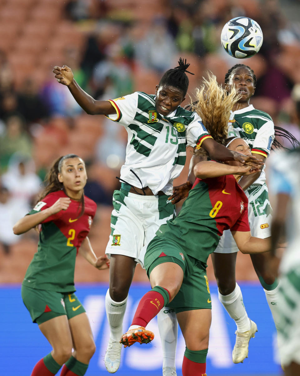 Portugal's Andrea Norton, centre, battles for the ball with Cameroon's Eleane Bibout and Claudine Meffometou, right, during their FIFA women's World Cup qualifier in Hamilton, New Zealand, Wednesday, Feb. 22, 2023. (Martin Hunter/Photosport via AP)