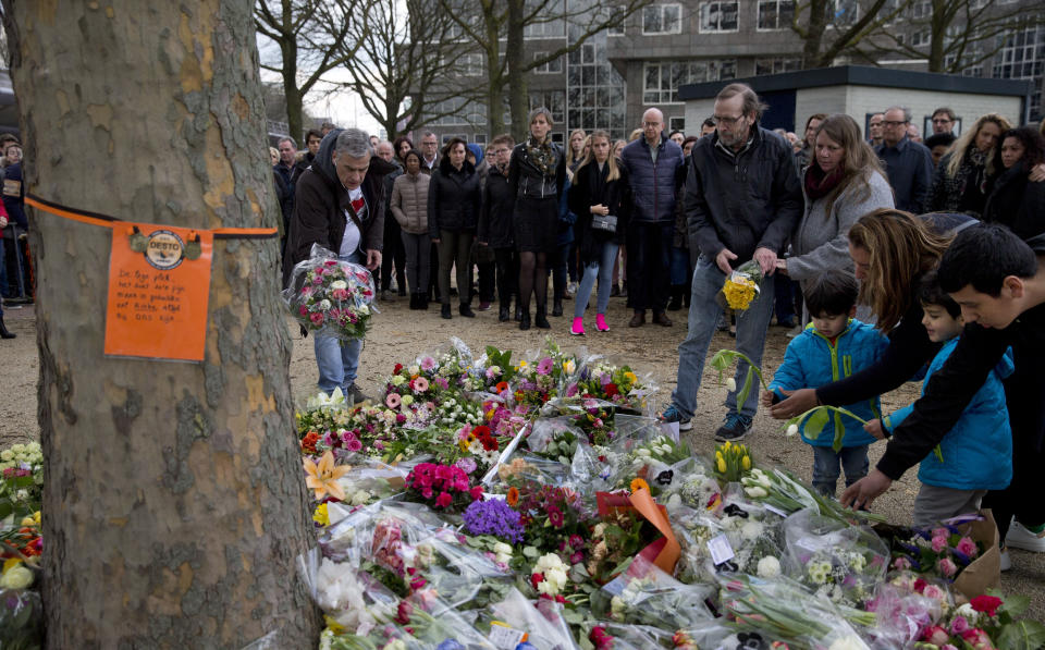 People lay flowers at a makeshift memorial site for the victims of a shooting incident in a tram in Utrecht, Netherlands, Tuesday, March 19, 2019. A gunman killed three people and wounded others on a tram in the central Dutch city of Utrecht Monday March 18, 2019. (AP Photo/Peter Dejong)