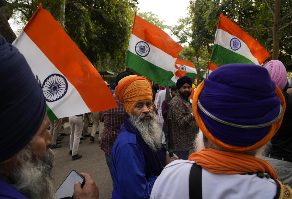 FILE- Indian Sikhs protesting against the pulling down of Indian flag from the Indian High Commission building in London gather with Indian flags outside the British High Commission in New Delhi, India, Monday, March 20, 2023. Footage posted on social media showed a man detach the Indian flag from a balcony of the building while a crowd of people below waving bright yellow "Khalistan" banners appeared to encourage him. Indian police have launched a manhunt for a Sikh separatist leader who has revived calls for an independent Sikh homeland, stirring fears of violence in northwestern Punjab state that has a history of bloody separatist insurgency. (AP Photo/Manish Swarup)