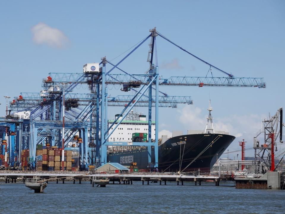 A container ship docked at Mombasa port, Kenya, with loading cranes in view.