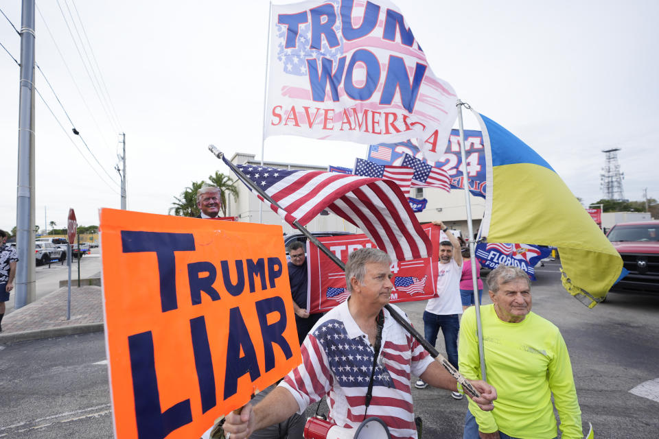 Philip Stasik, center, holds up a "Trump Liar," sign as he joins demonstrators, mostly supporters of former President Donald Trump, at the Federal Courthouse, Friday, March 1, 2024, in Fort Pierce, Fla. (AP Photo/Wilfredo Lee)