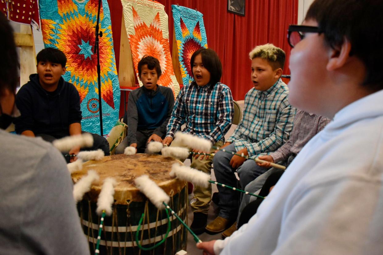 Students from Rosebud Elementary School perform in a drum circle during a meeting about abusive conditions at Native American boarding schools at Sinte Gleska University on the Rosebud Sioux Reservation in Mission, S.D., Saturday, Oct. 15, 2022.