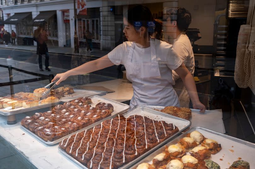 A young woman serving buns from the shop Buns From Home in Covent Garden the on 25th April 2023 in London