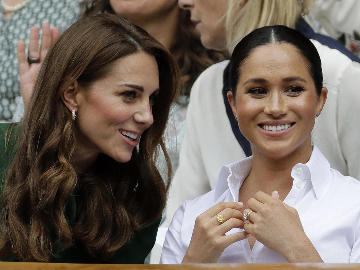 Kate, Duchess of Cambridge, left, and Meghan, Duchess of Sussex chat as they sit in the Royal Box on Centre Court to watch the women's singles final match between Serena Williams of the United States and Romania's Simona Halep on day twelve of the Wimbledon Tennis Championships in London: AP