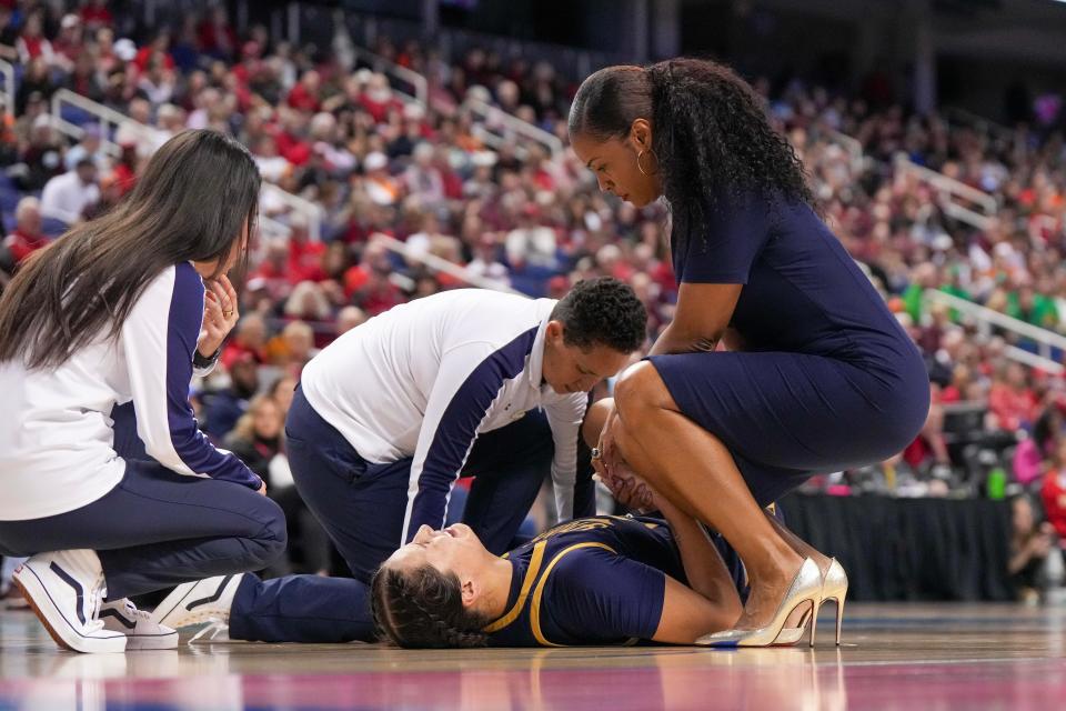 Mar 9, 2024; Greensboro, NC, USA; Notre Dame Fighting Irish forward Kylee Watson (22) is assisted after an injury during the second half against the Virginia Tech Hokies at Greensboro Coliseum. Mandatory Credit: David Yeazell-USA TODAY Sports