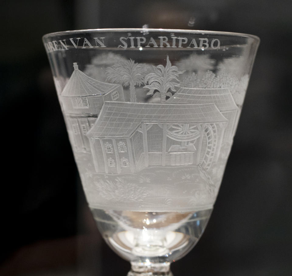 A ceremonial glass commissioned by plantation owners is seen at the Slavery exhibition at the Rijksmuseum in Amsterdam, Netherlands, Monday, May 17, 2021. The stark contrast between finery and brutality, wealth and inhumanity is a recurring pattern at the museum's unflinching new exhibition titled, simply, "Slavery", that examines the history of Dutch involvement in the international slave trade. (AP Photo/Peter Dejong)
