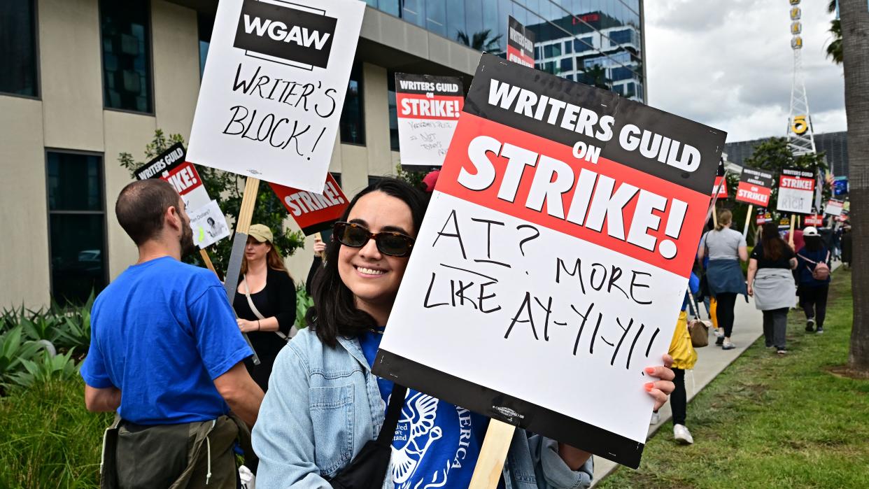  Writer Ilana Pena holds her sign on the picket line on the fourth day of the strike by the Writers Guild of America in front of Netflix in Hollywood, California, on May 5, 2023. - The Hollywood writers' strike broke out this week over pay, but the refusal of studios like Netflix and Disney to rule out artificial intelligence replacing human scribes in the future has only fueled anger and fear on the picket lines. With their rapidly advancing ability to eerily mimic human conversation, AI programs like ChatGPT have spooked many industries recently. 