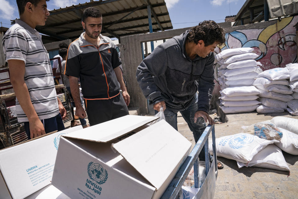 Bags of foodstuffs provided by the United Nations Relief and Works Agency for Palestine Refugees in the Near East (UNRWA) as Palestinians collect food aid following a cease-fire reached after an 11-day war between Gaza's Hamas rulers and Israel, in Gaza City, Saturday, May 22, 2021. (AP Photo/John Minchillo)