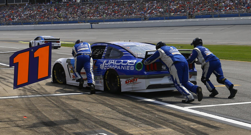 Cody Ware's crew pushes his car into the pit box after he ran out of gas during a NASCAR Cup Series auto race at Talladega Superspeedway, Sunday, April 28, 2019, in Talladega, Ala. (AP Photo/Butch Dill)