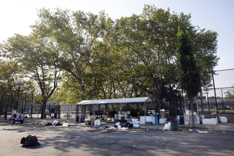 FILE - In this July 28, 2019 file photo, the remains of a party litter a playground after a shooting in the Brownsville neighborhood in the Brooklyn borough of New York. New York City police have made an arrest in the community festival shooting that left one person dead and 11 wounded this summer. Police said Wednesday, Oct. 16, that 20-year-old Kyle Williams, of Brooklyn, was arrested on murder, criminal possession of a weapon, reckless endangerment and attempted murder charges. (AP Photo/Mark Lennihan, File)