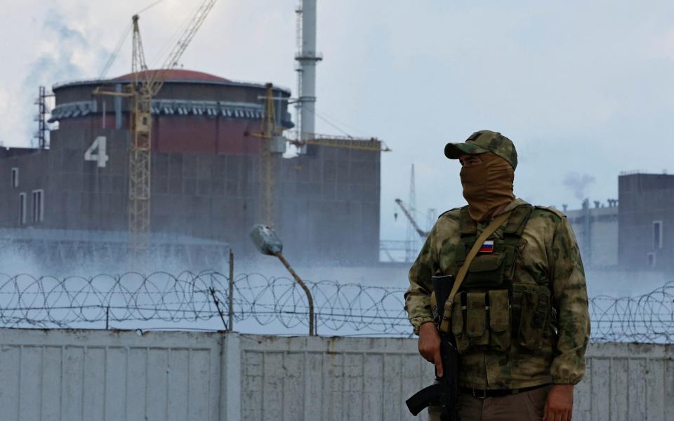 A serviceman with a Russian flag on his uniform stands guard near the Zaporizhzhia nuclear power plant - Alexander Ermochenko/Reuters