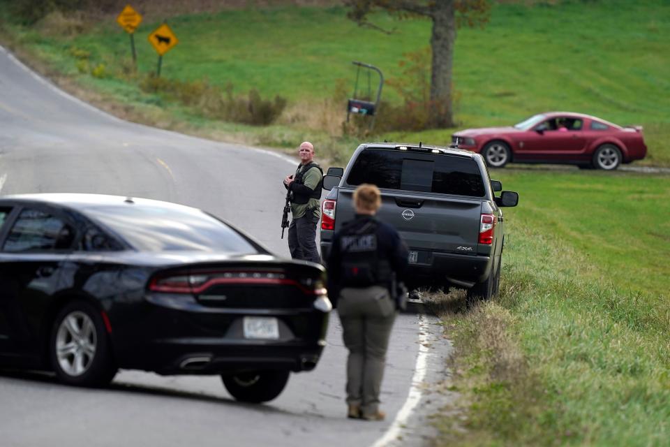 Law enforcement officers hold rifles while investigating a scene, in Bowdoin, Maine, Thursday, Oct. 26, 2023. Residents have been ordered to shelter in place as police continue to search for the suspect of Wednesday's mass shootings. (AP Photo/Steven Senne)