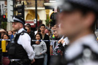 <p>People stand beyond a police cordon outside a row of stores in East Ham in London, June 4, 2017, following a raid as police continue their investigations following the June 3 terror attacks in central London. (Photo: Justin Tallis/AFP/Getty Images) </p>