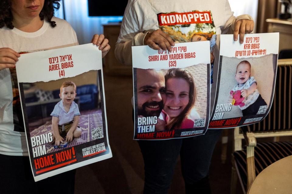 PHOTO: Ofri Bibas Levy, whose brother Yarden was taken hostage with his wife Shiri and 2 children Kfir and Ariel holds with her friend Tal Ulus pictures of them during an interview with Reuters in Geneva, Switzerland, Nov. 13, 2023.  (Denis Balibouse/Reuters)