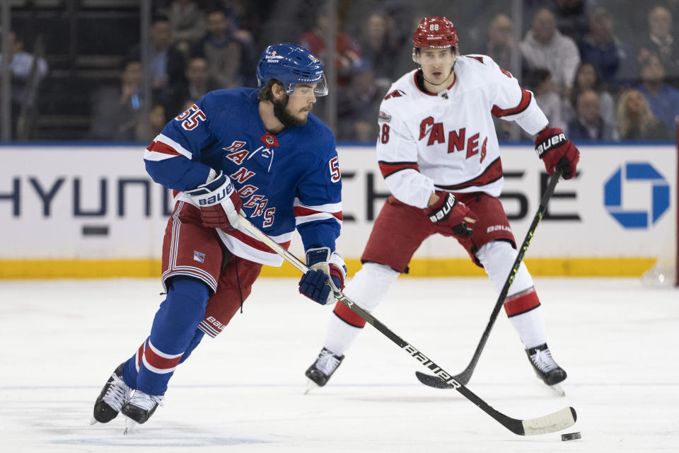 New York Rangers defenseman Ryan Lindgren (55) controls the puck while skating near Carolina Hurricanes center Martin Necas (88) during the first period of an NHL hockey game Tuesday, March 21, 2023, at Madison Square Garden in New York. (AP Photo/Mary Altaffer)