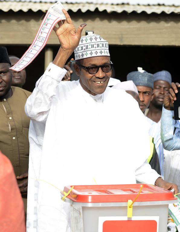 Main opposition All Progressives Congress (APC) presidential candidate Mohammadu Buhari holds his ballot paper prior to casting his vote at a polling station in Daura, Nigeria, on March 28, 2015