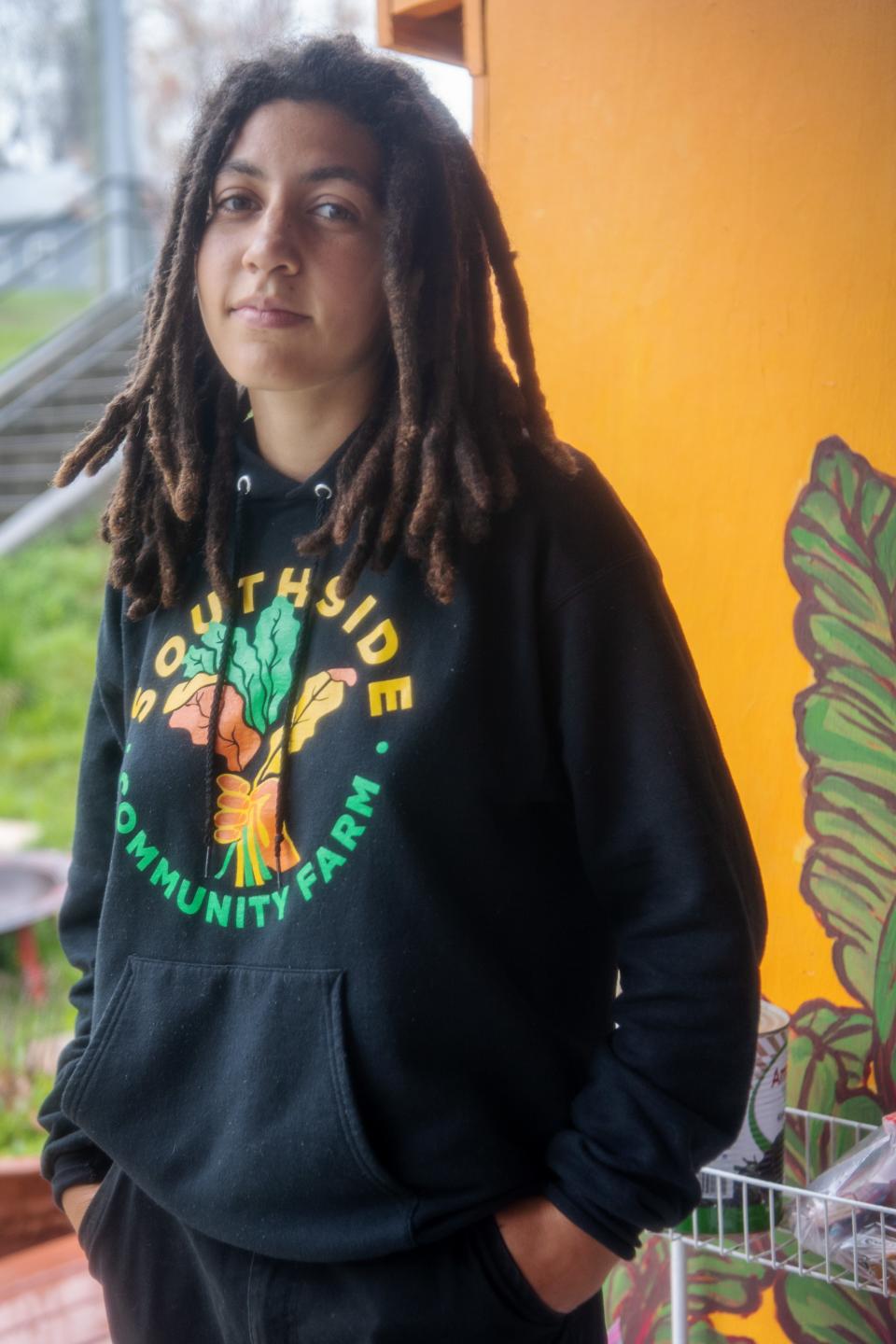 Southside Community Farm manager Chloe Moore stands next to a refrigerator of free food at the farm, April 11, 2024.