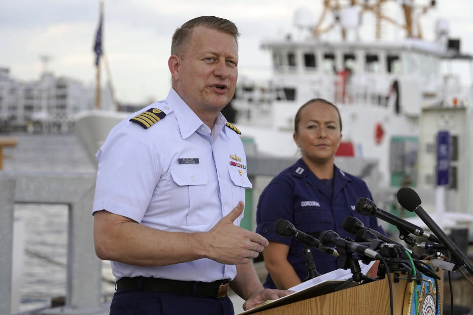 Capt. Jason Neubauer, chief investigator, U.S. Coast, left, speaks with the media as Samantha Corcoran, public affairs officer of the First Coast Guard District, right, looks on during a news conference, Sunday, June 25, 2023, at Coast Guard Base Boston, in Boston. The U.S. Coast Guard said it is leading an investigation into the loss of the Titan submersible that was carrying five people to the Titanic, to determine what caused it to implode. (AP Photo/Steven Senne)