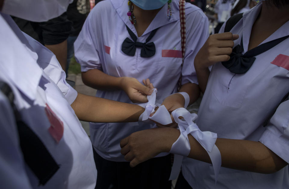 High school students tie white- ribbons, symbol of their protest moment ahead of a protest rally in Bangkok, Thailand, Saturday, Sept. 5, 2020. The student's demonstration comes at a time of mass anti-government protests led predominantly by university students, putting added strain on the under-pressure administration of Prime Minister Prayuth Chan-ocha. (AP Photo/Gemunu Amarasinghe)