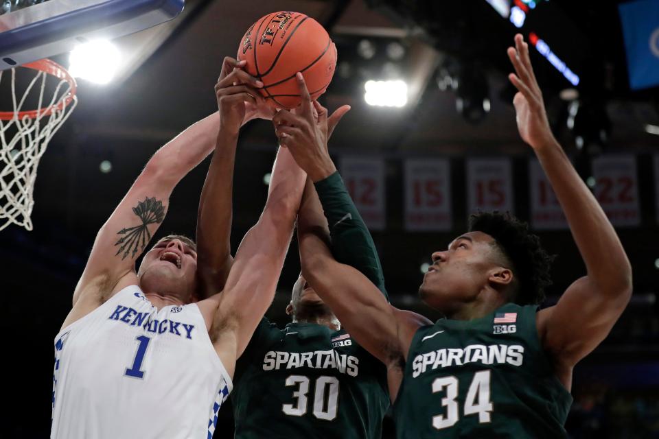 Kentucky forward Nate Sestina (1) vies for a rebound with Michigan State forwards Marcus Bingham Jr. (30) and Julius Marble (34) during the first half of an NCAA college basketball game Tuesday, Nov. 5, 2019, in New York. (AP Photo/Adam Hunger)