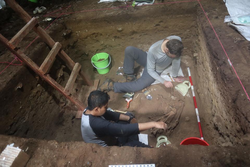 Archaeologists Andika Priyatno (left) and Tim Maloney (right) work on "Skully" (Liang Tebo 1) in Liang Tebo cave in East Kalimantan, Indonesian Borneo.