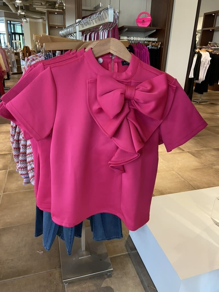 A shirt with a huge pink bow on it