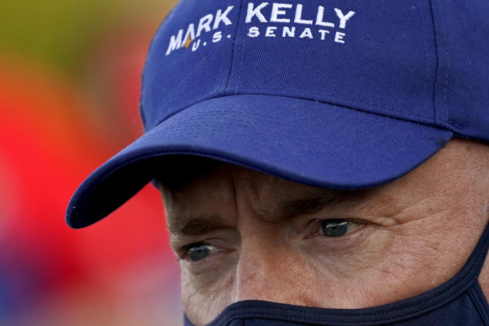 Mark Kelly, Democratic candidate for the U.S. Senate, greets voters at a polling station, Tuesday, Nov. 3, 2020, in Phoenix. Kelly is seeking to unseat incumbent Martha McSally. (AP Photo/Matt York)