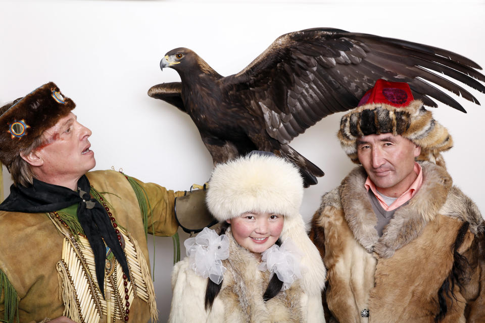 Eagle Huntress, Ashol-Pan, center, poses with her father and an eagle for a portrait to promote the film, "Eagle Huntress", at the Toyota Mirai Music Lodge during the Sundance Film Festival on Saturday, Jan. 23, 2016 in Park City, Utah. (Photo by Matt Sayles/Invision/AP)